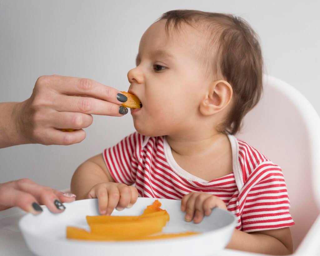 Baby trying soft finger foods like melon as part of a baby-led and spoon-fed solids introduction.