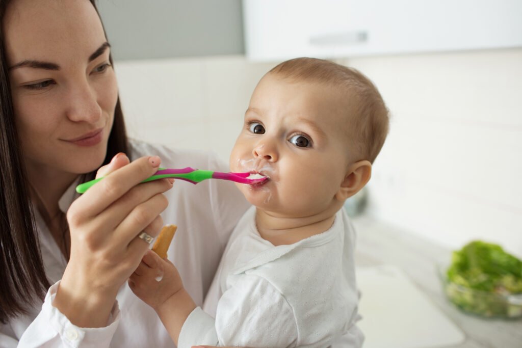 Mother spoon-feeding her baby as part of a combined babyfed and spoon-fed weaning approach.