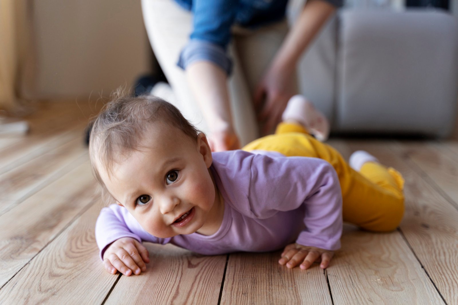 Parent pausing while baby fusses on tummy in cot, allowing time to self-settle