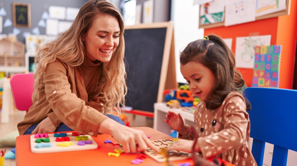 Toddler explores a colourful childcare room with their parent nearby for reassurance during an orientation visit before their first day